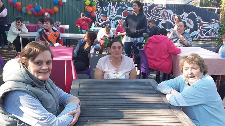 Lots of people sitting outside at tables