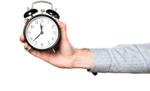 a person holding a bed clock out