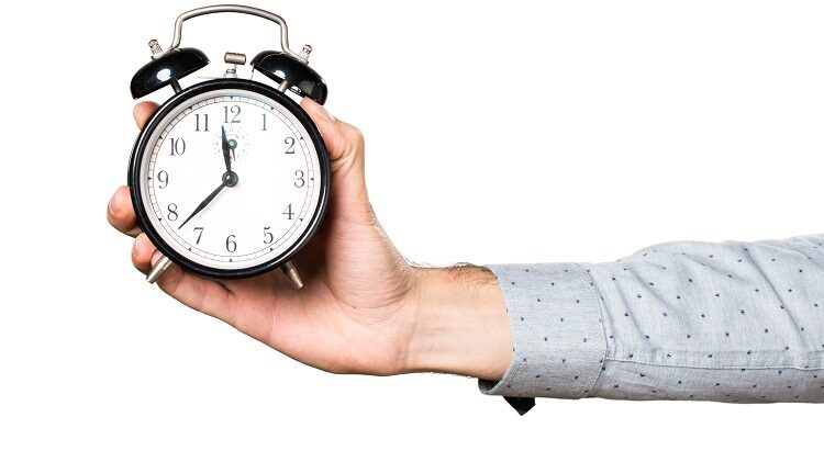 a person holding a bed clock out