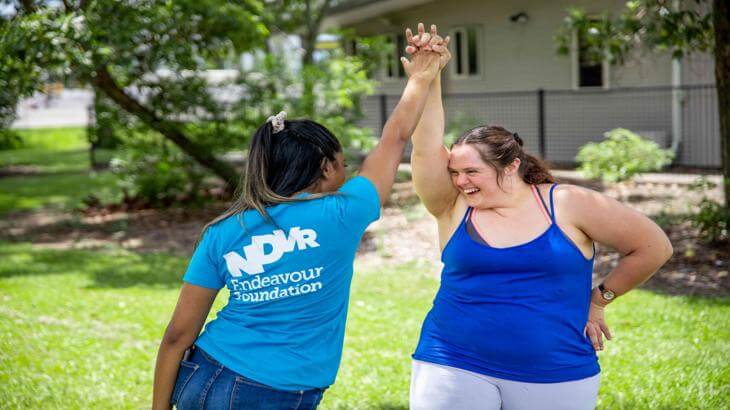 2 people holding hands up high