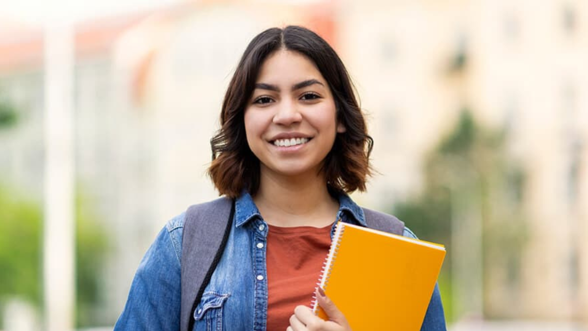 Women who is smiling holding a notebook.