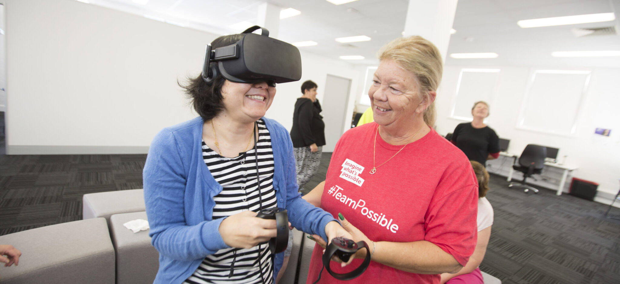 Women with support worker learning to use the VR system.